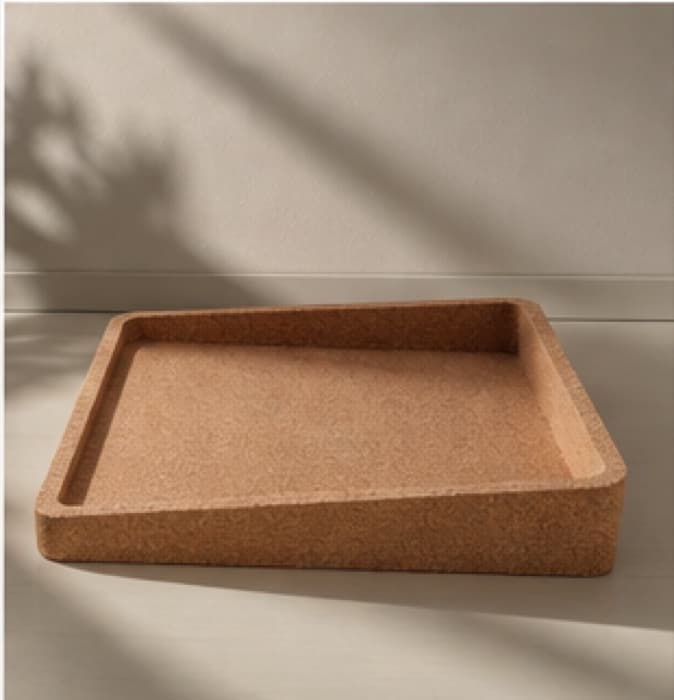 The bare cork tray, its grain and moulded rim visible in raking light