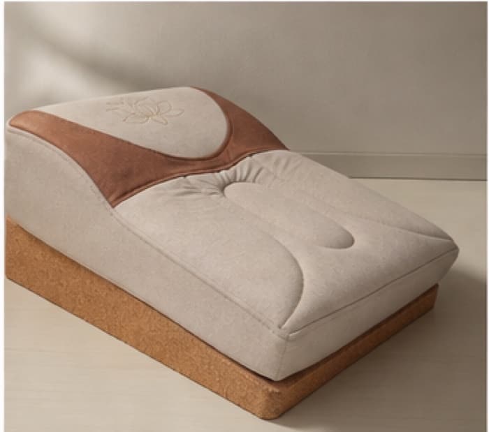 Three-quarter side view of the seat, the comfort layer ramping from a thin front edge up to the raised rear crest