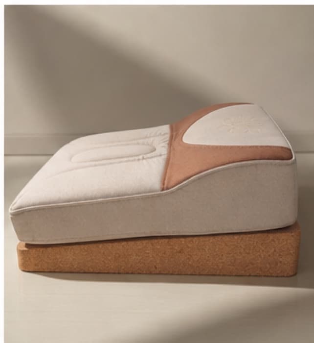 Side elevation of The Lotus Seat: the cushion rises front to back over a solid cork base, forming the 8° wedge